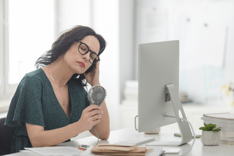 Mature woman suffering hot flash in the office