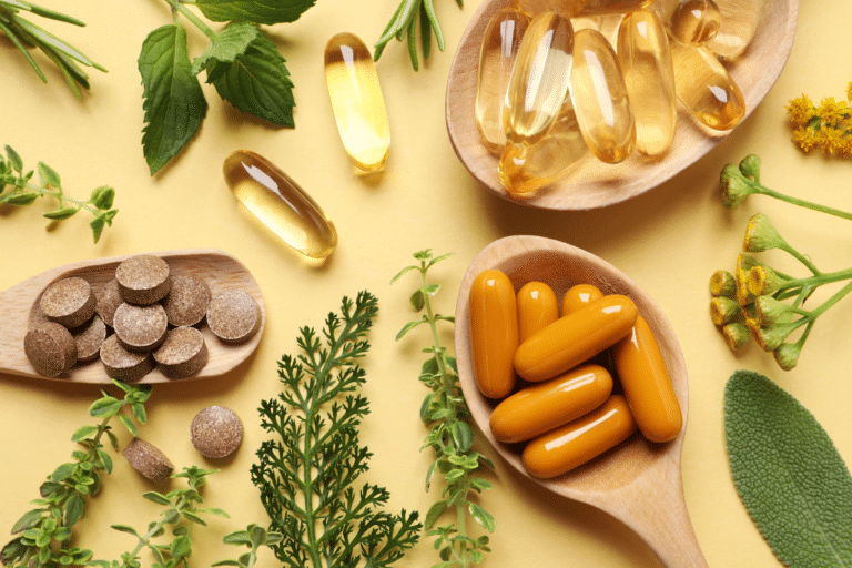 Different supplements, pills and herbs on pale orange background, flat lay.