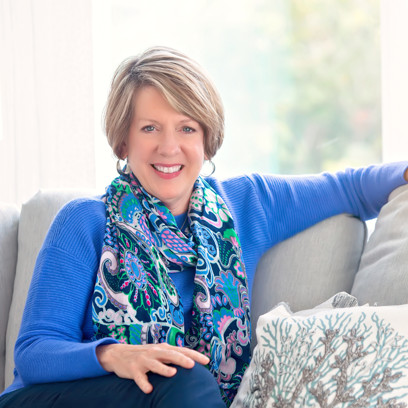 Professional headshot of Dr. Anna Garrett, functional medicine practitioner specializing in women's hormones, wearing blue sweater and colorful scarf
