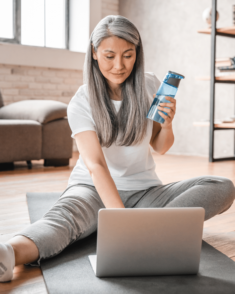 Vertical portrait of a middle-aged woman using laptop for training at home
