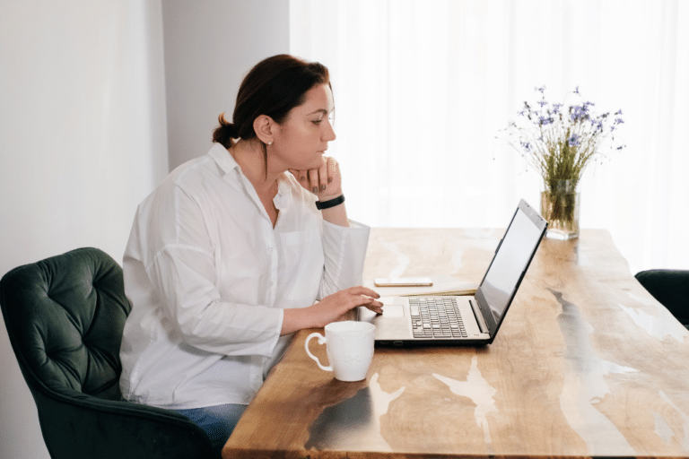 Midlife woman researching HRT and GLP-1 medications on her laptop at home.